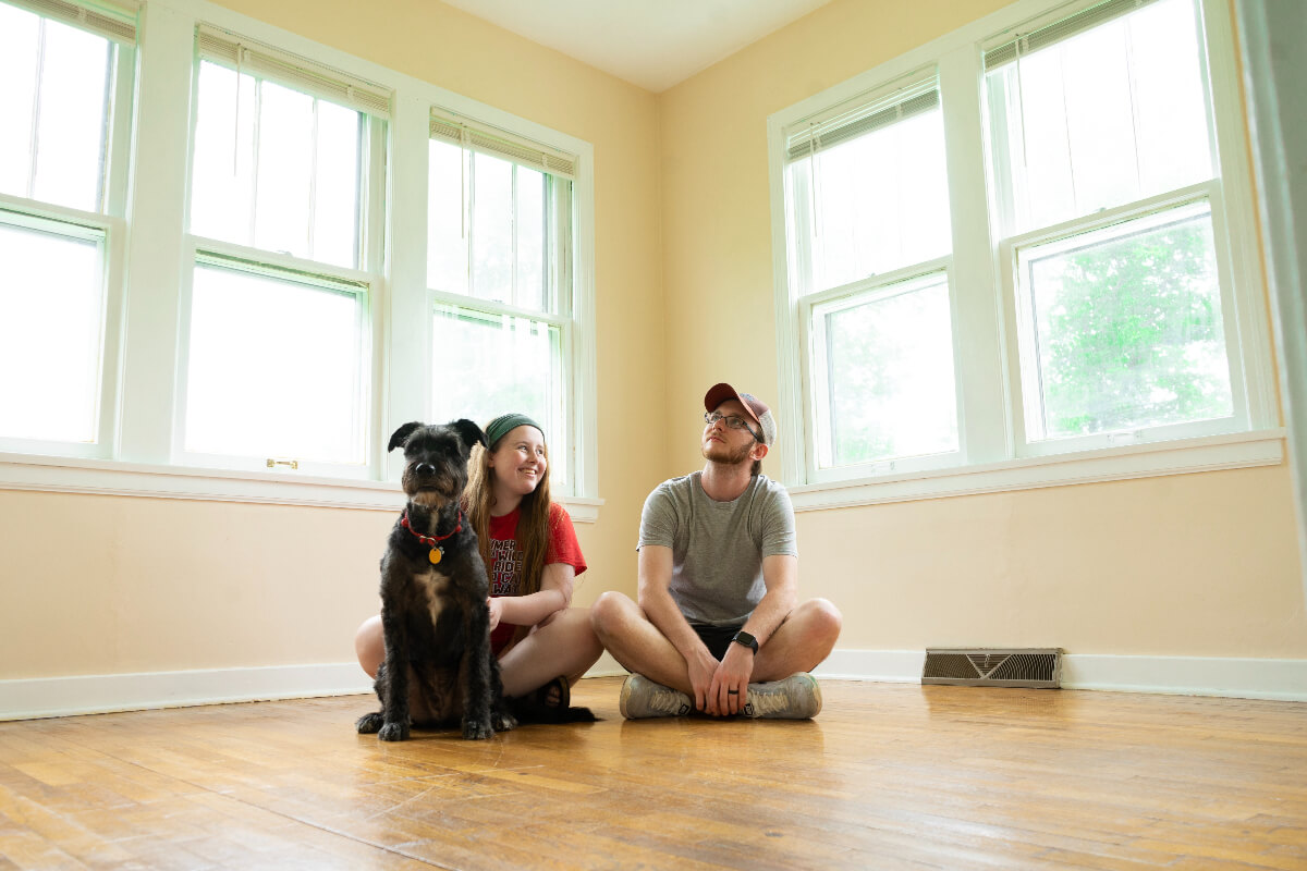 Happy family sitting on floor in their new home after their home inspection
.